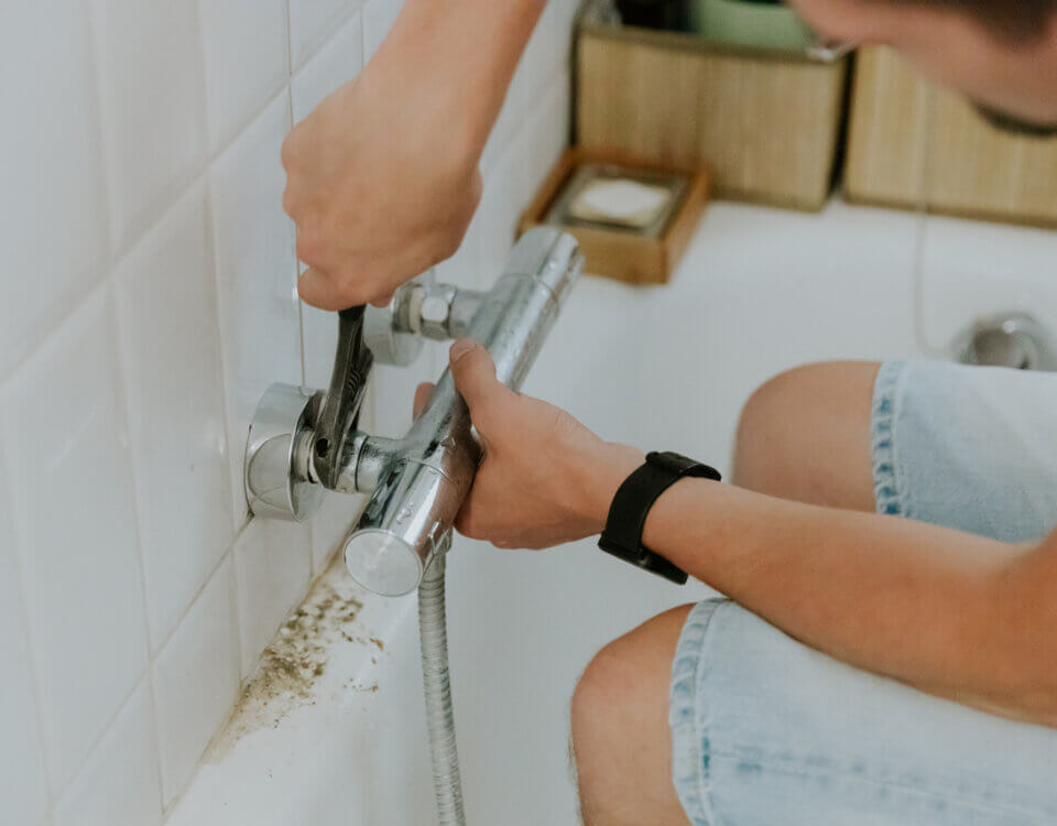 man-installs-a-faucet-in-the-bathroom